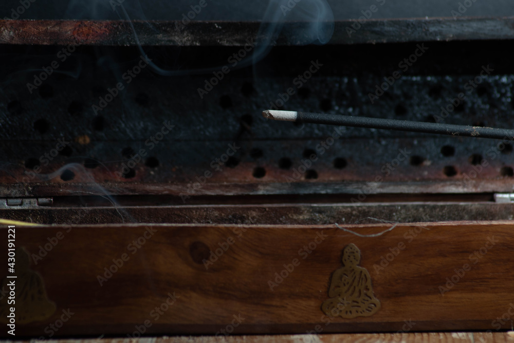 Incense sticks with smoke and in the gloomy background religion and buIncense sticks with smoke and in the gloomy background religion and buddha