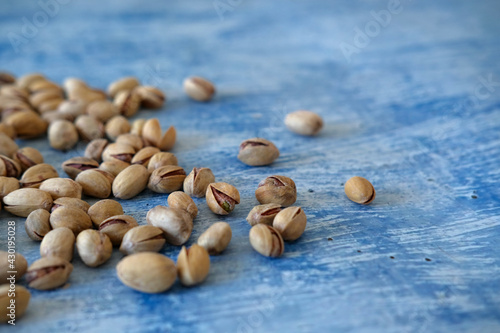 Close-up of Salted and dried Pistachios on the Blurred painted stone table as background. Concept of healthy nutrition. Selective focus. Copy space.