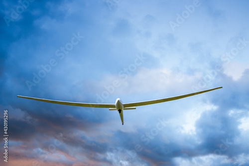 a sailplane glider soaring through the clouds on a summer day
