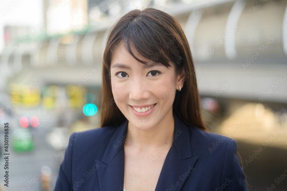 Portrait of beautiful young asian business woman is working in modern city