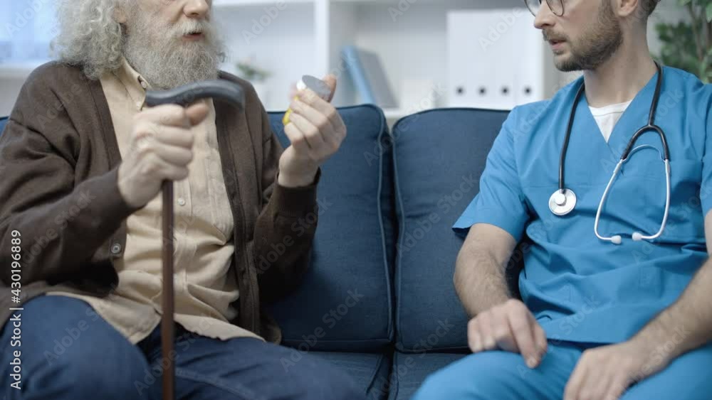 Elderly pensioner taking pills from doctor, home care, treatment of disease Elderly pensioner taking pills from doctor, home care, treatment of disease