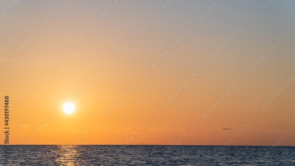 Sunset sky over sea in the evening with colorful orange sunlight with warm in summer season