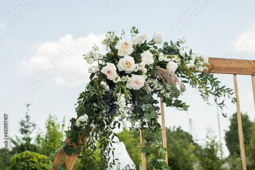 Close up of wedding eco decor with white fresh white flowers on wood arch