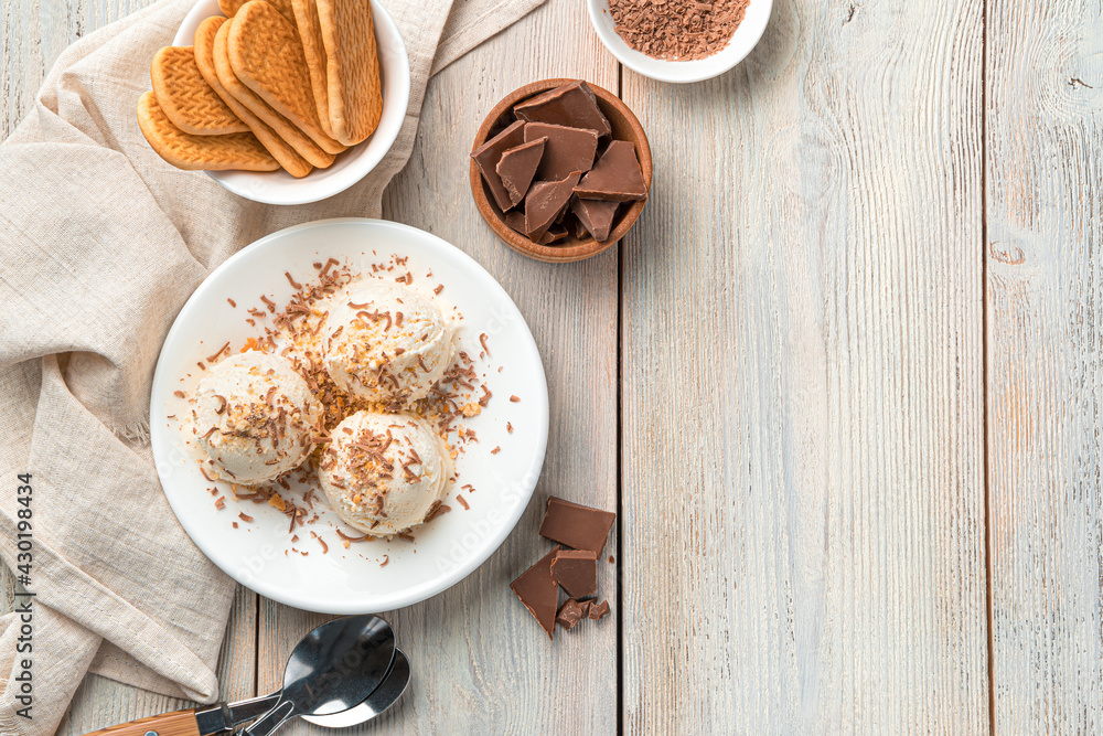 Three balls of ice cream with chocolate chips and cookie crumbs in a white plate on a light background. Three balls of ice cream with chocolate chips and cookie crumbs in a white plate on a light background.