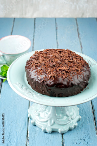 Traditional Austrian Sacher chocolate cake with crumbles served as close-up on an ceramic cake plate photo