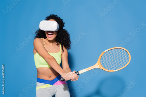 amazed african american woman in vr headset playing tennis on blue © LIGHTFIELD STUDIOS