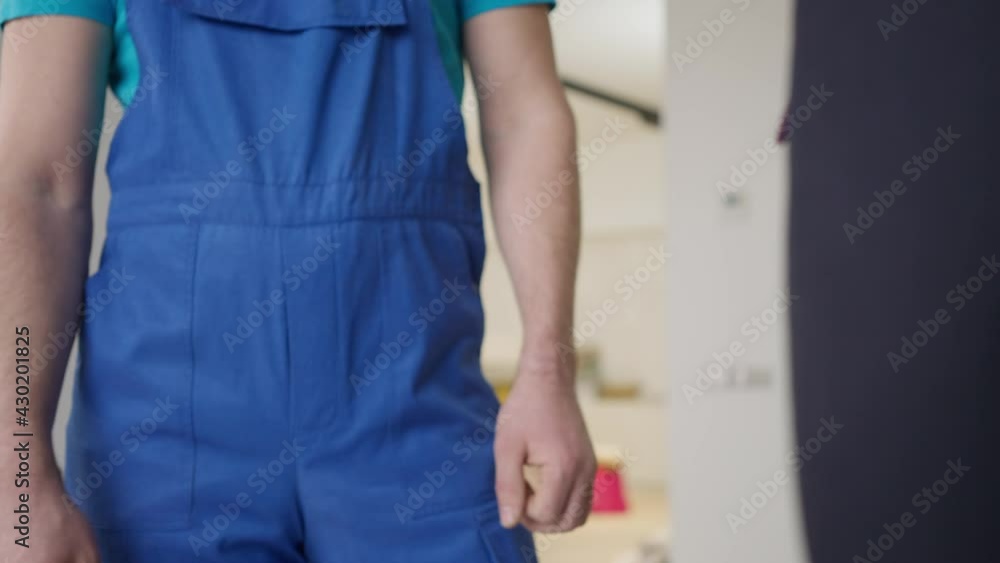 Unrecognizable businessman and service man shaking hands indoors. Handshake of satisfied Caucasian property owner and professional foreman. Real estate business and agreement concept Unrecognizable businessman and service man shaking hands indoors. Handshake of satisfied Caucasian property owner and professional foreman. Real estate business and agreement concept
