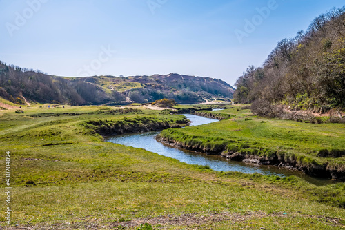 A view of the meanders of Pennard Pill stream that flows out to Three Cliffs Bay, Gower Peninsula, Swansea, South Wales on a sunny day