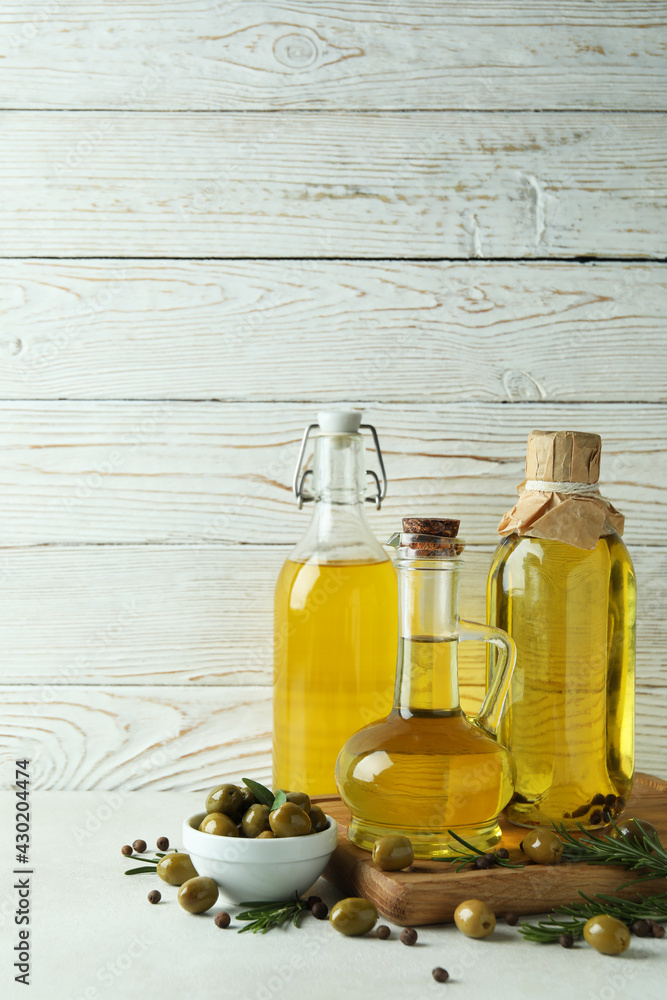 Bottles of olive oil against white wooden background Bottles of olive oil against white wooden background
