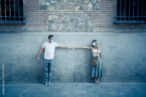 Man and woman keeping social distancing outdoors city street. COVID-19 and social interactions © SB Arts Media