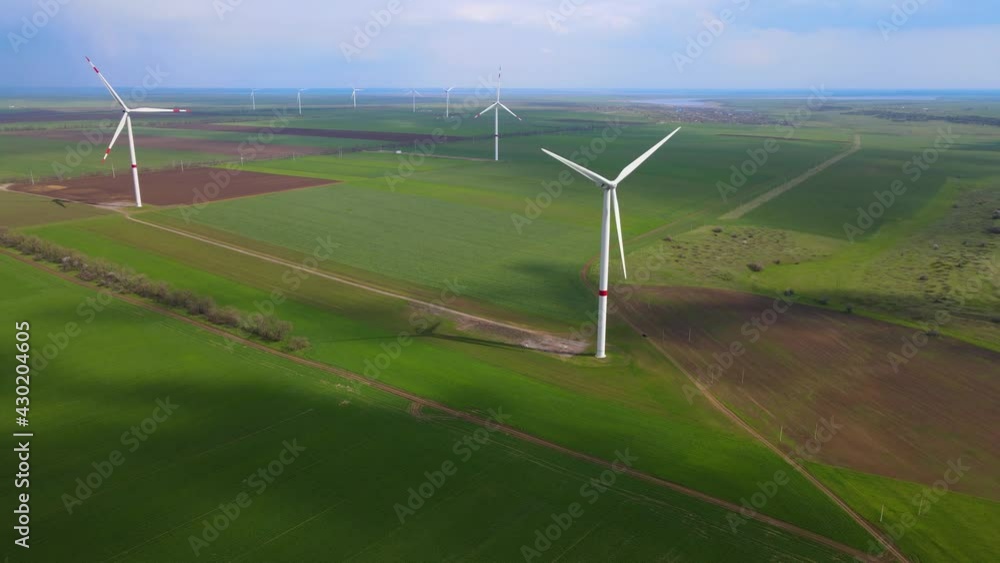 Wind farms that generate clean renewable energy for sustainable development. Alternative energy. Large wind turbines with blades in the field aerial view. Wind farms that generate clean renewable energy for sustainable development. Alternative energy. Large wind turbines with blades in the field aerial view.