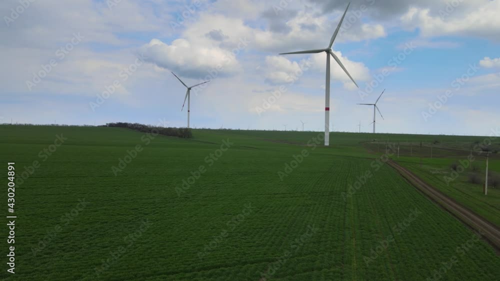 Wind farms that generate clean renewable energy for sustainable development. Alternative energy. Large wind turbines with blades in the field aerial view. Wind farms that generate clean renewable energy for sustainable development. Alternative energy. Large wind turbines with blades in the field aerial view.