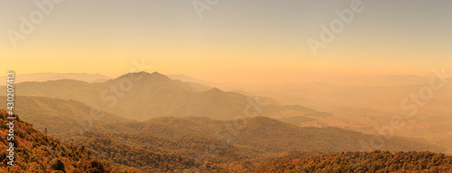 Panorama landscape photo of mountain hill and forest at sunset or evening time. warm light tone.
