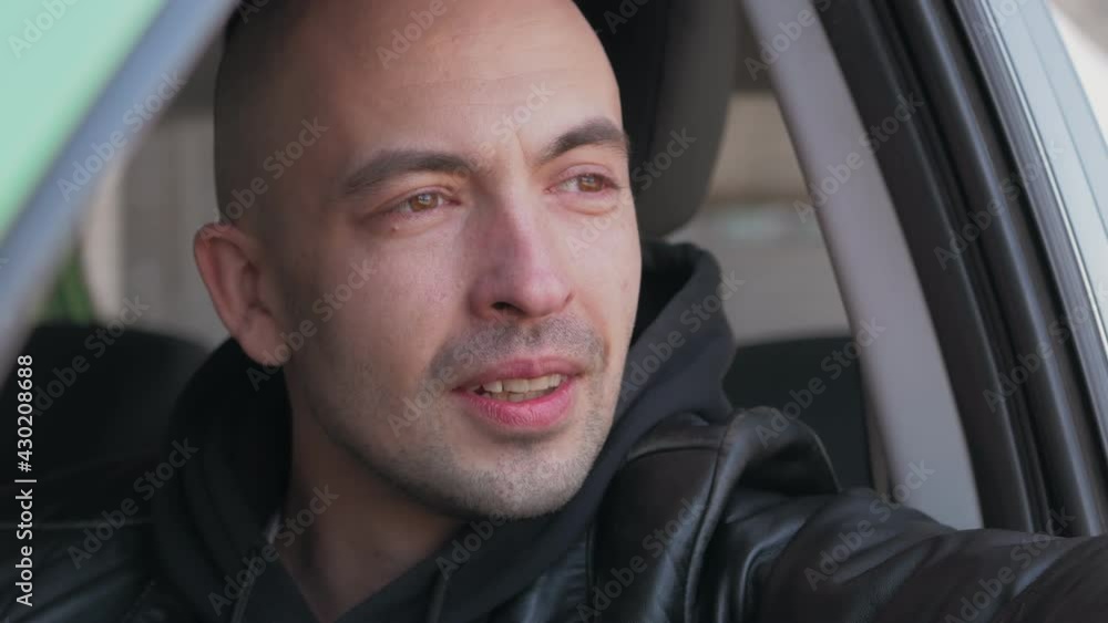 Portrait of a man looking out of the window of a parked car. Portrait of a man looking out of the window of a parked car.
