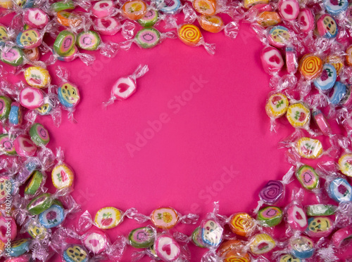 Colorful candies on a pink background top view stock images. Sweets on a pink background with copy space for text. Pile of candies on a pink background frame. Candy with heart stock images