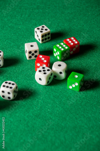 Fotografie Top view of green baize with white, green and red dice, vertically, with copy sp