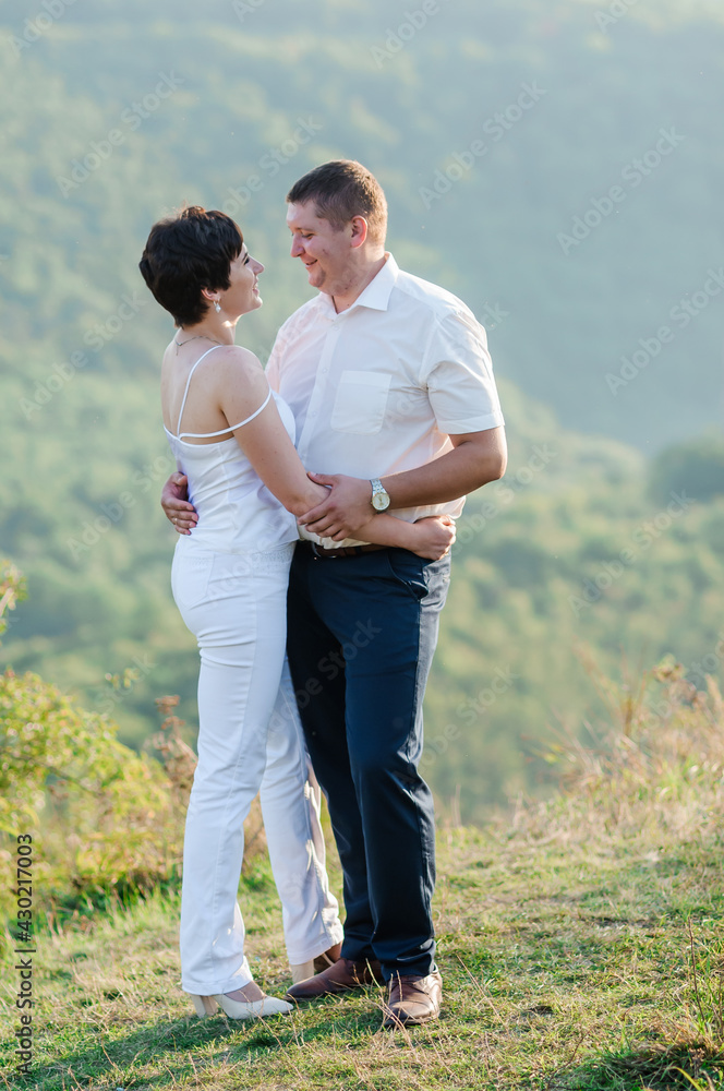 Newlyweds hug and kiss on the background of the forest. A man hugs and kisses a woman Newlyweds hug and kiss on the background of the forest. A man hugs and kisses a woman