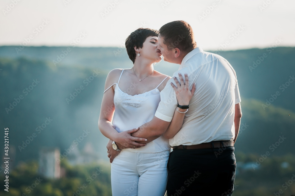 Newlyweds hug and kiss on the background of the forest. A man hugs and kisses a woman Newlyweds hug and kiss on the background of the forest. A man hugs and kisses a woman
