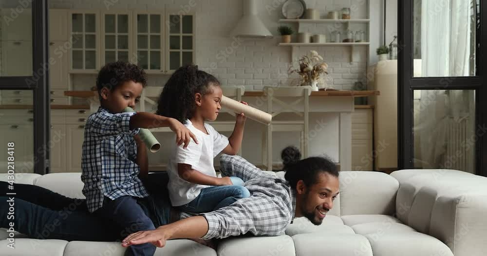 Overjoyed little cute african american brother and sister sitting on father, playing imagination creative pirates game. Sincere happy different generations mixed race family having fun at home. Overjoyed little cute african american brother and sister sitting on father, playing imagination creative pirates game. Sincere happy different generations mixed race family having fun at home.