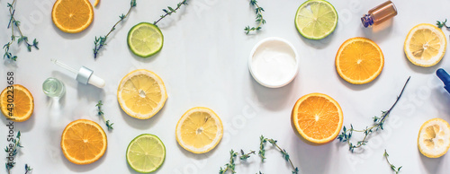 Natural citrus cosmetics with vitamin C, cosmetic bottles, citrus circles, lime, orange, lemon, top view, flat lay, copy space