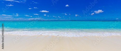 Closeup of sand on beach and blue summer sky. Panoramic beach landscape. Empty tropical beach and seascape. Vacation coast  shore blue sky  soft sand  calmness  tranquil relaxing sunlight  summer mood