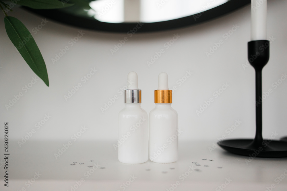 two white bottle with dropper cap. The concept of beauty. Cosmetics for home care. two white bottle with dropper cap. The concept of beauty. Cosmetics for home care.