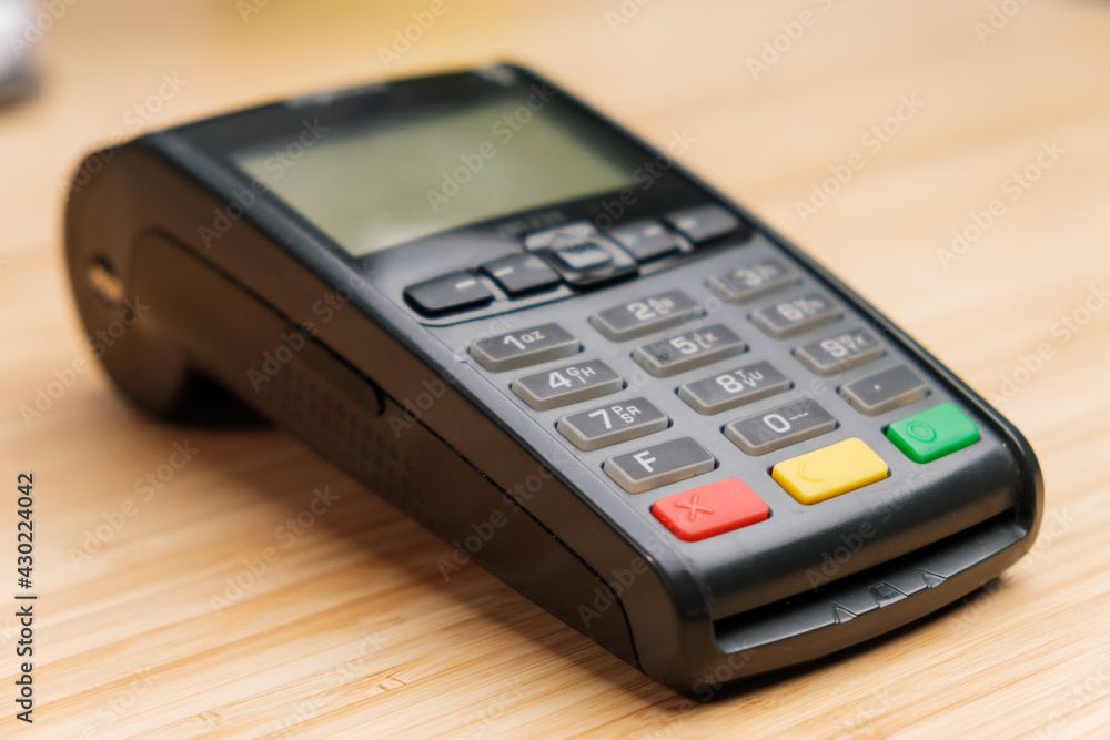 POS terminal on the wooden desk with copy space. Contactless payment with NFC technology POS terminal on the wooden desk with copy space. Contactless payment with NFC technology
