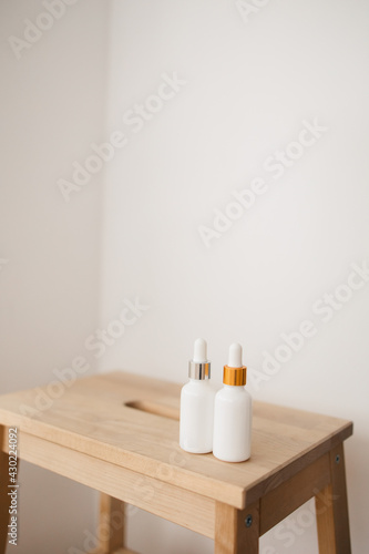 two white bottle with dropper cap. The concept of beauty. Cosmetics for home care.
