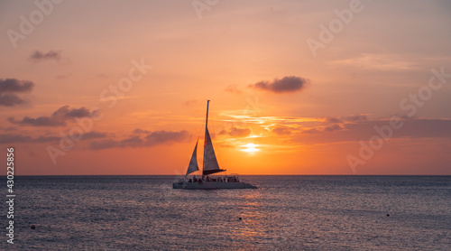 Fotografia sunset at eagle beach in aruba in the caribbean with catamaran in composition
