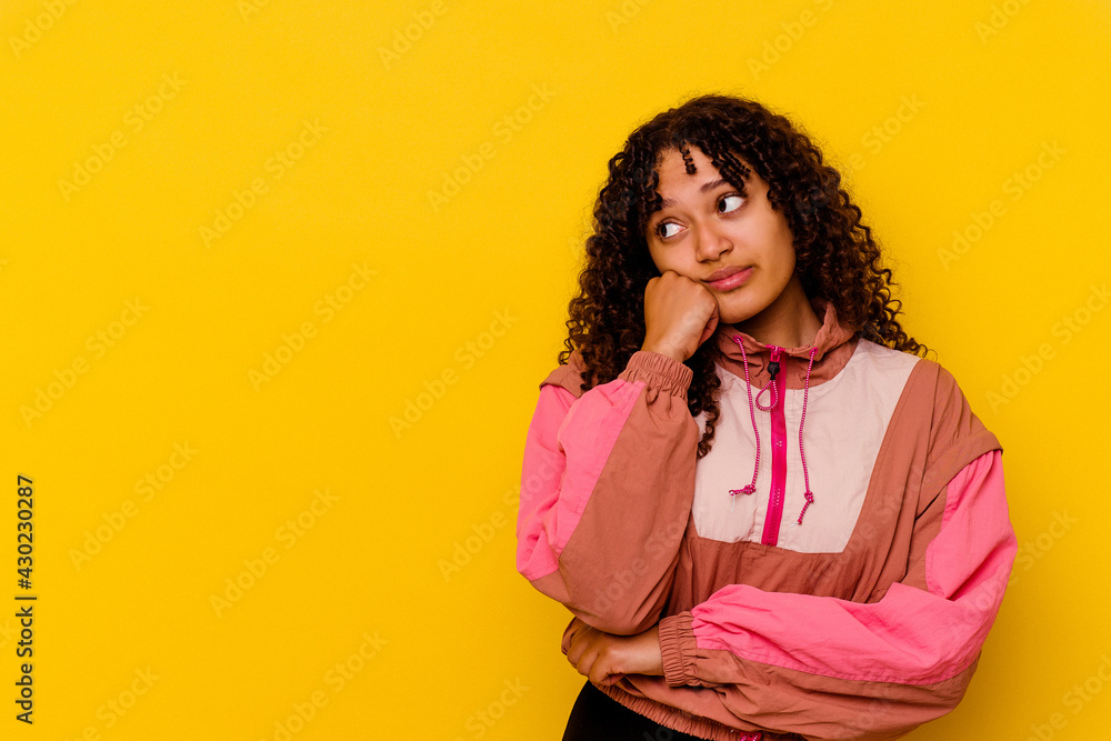 Young mixed race woman isolated on pink background who feels sad and pensive, looking at copy space. Young mixed race woman isolated on pink background who feels sad and pensive, looking at copy space.
