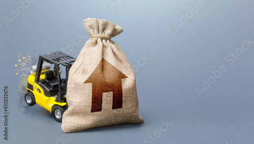 Obraz na plátně Forklift truck cannot lift the bag with house symbol