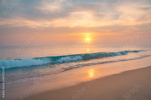 Waves on the sandy ocean beach under a beautiful sunset sky with clouds on Sri Lanka island. © stone36
