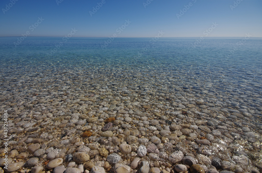 The seabed of pebbles seen through clean and transparent water.