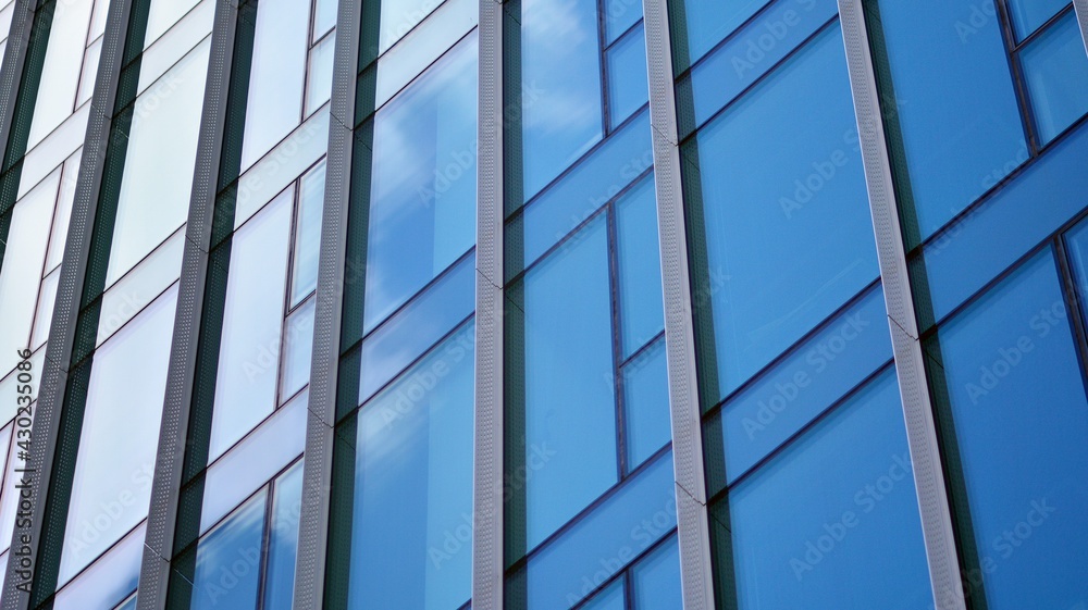 Modern office building detail, glass surface on a clear sky background. Transparent glass wall of office building. Modern office building detail, glass surface on a clear sky background. Transparent glass wall of office building.