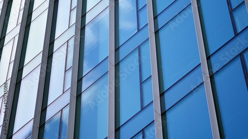 Modern office building detail, glass surface on a clear sky background. Transparent glass wall of office building. 