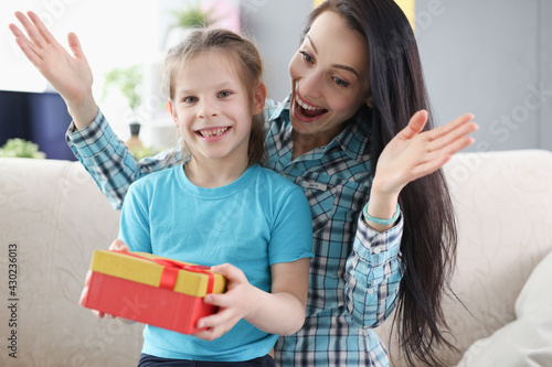 Woman and girl rejoice at surprise in gift box