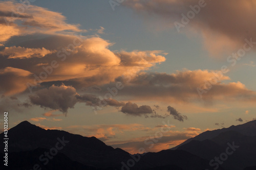 Inspirational background. Dramatic sunset in the mountains. Cloudscape. View of the hills dark silhouette  beautiful clouds and sky with dusk colors.
