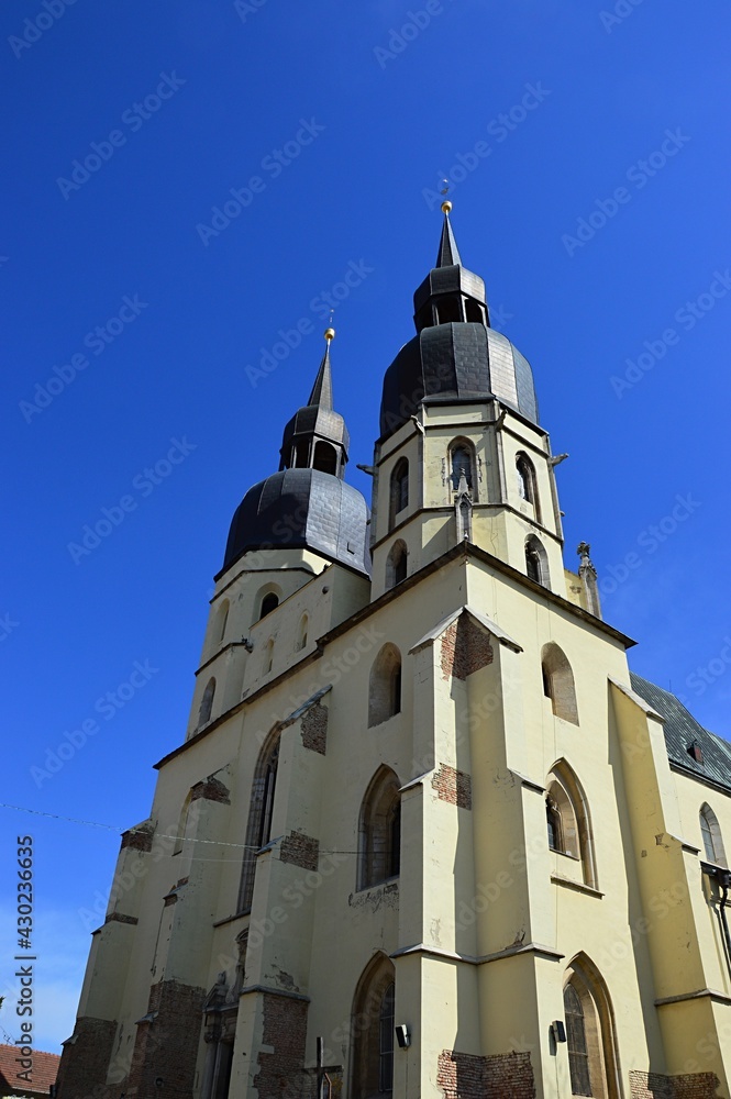 Two massive towers of gothic cathedral of Saint Nicholas in Trnava, western Slovakia, central Europe. Spring daylight sunshine, clear blue skies.
