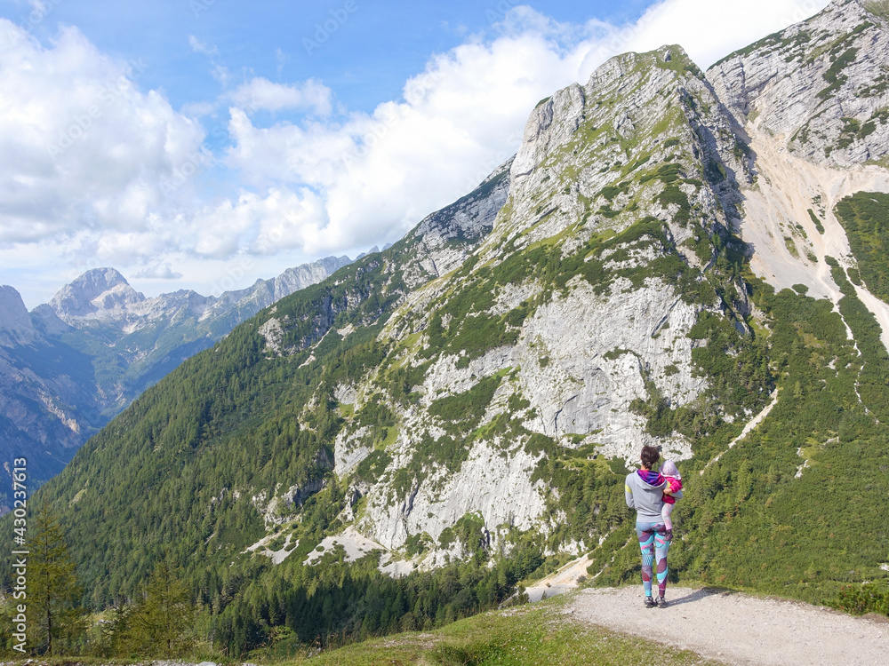 Woman with child is admiring the view of the mountains at Vrsic mountain pass in Slovenia.