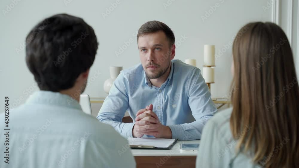 Happy young couple sitting together at the desk and sign mortgage contract meeting out in with realtor Happy young couple sitting together at the desk and sign mortgage contract meeting out in with realtor