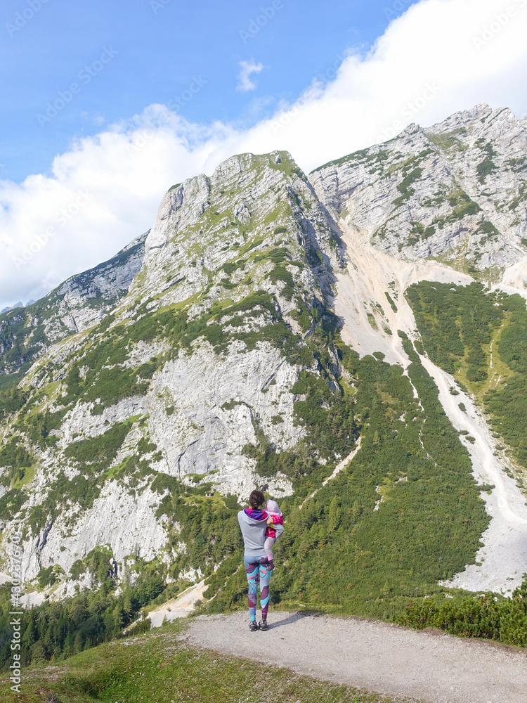 Woman with child is admiring the view of the mountains at Vrsic mountain pass in Slovenia.