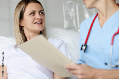 Doctor communicates with patient in hospital ward