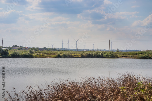 Windwheels ,lake and a field in rural Ukraine. Wind farm near the village photo