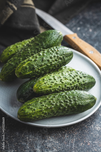 Fresh green cucumbers on black kitchen table.