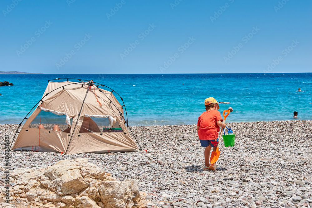 The amazing Kaladi beach, beautiful scenery with a young child, a boy playing on the beach. Ionian, Greece, Europe