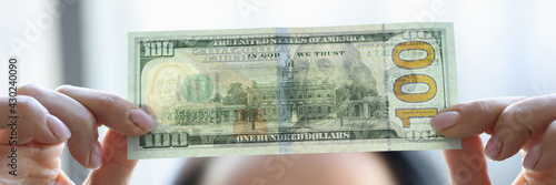 Woman holding dollar bill and looking at it with watermarks closeup