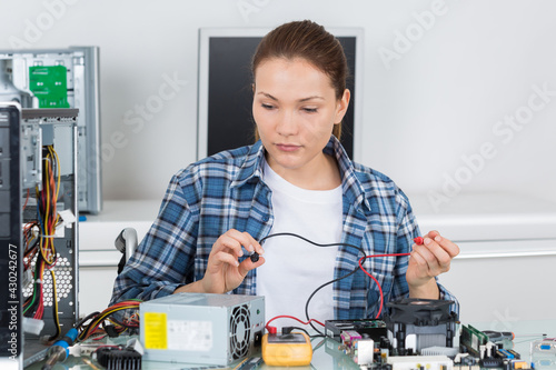 female computer technician using multimeter