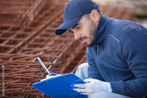 construction worker inspecting metal bar