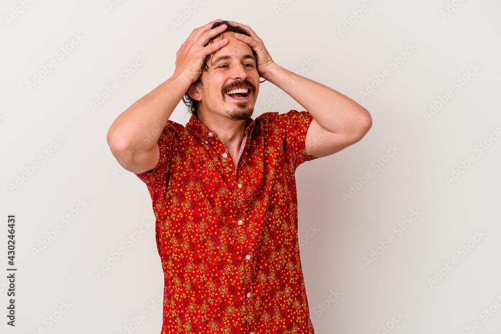 Young caucasian man isolated on white background laughs joyfully keeping hands on head. Happiness concept. Young caucasian man isolated on white background laughs joyfully keeping hands on head. Happiness concept.