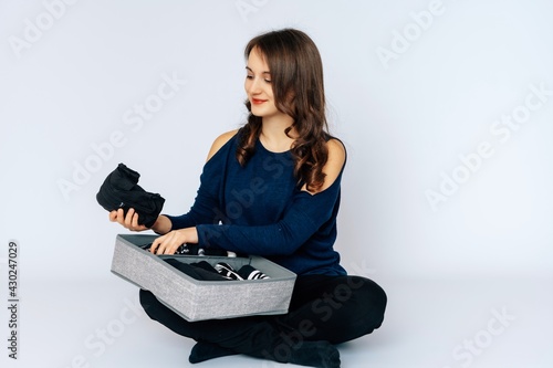 Junge hübsche Frau räumt Shirts auf Marie Kondo Methode, einräumen, Shirts sortieren, Ordnung, weißer Hintergrund, copy pace,